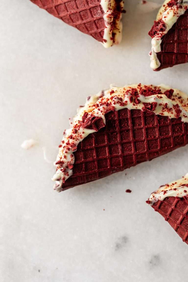 Homemade red velvet choco tacos with a red velvet infused waffle shell, creamy vanilla bean ice cream and a white chocolate shell. A twist on the classic treat and a recipe fitting for summer and Juneteenth.