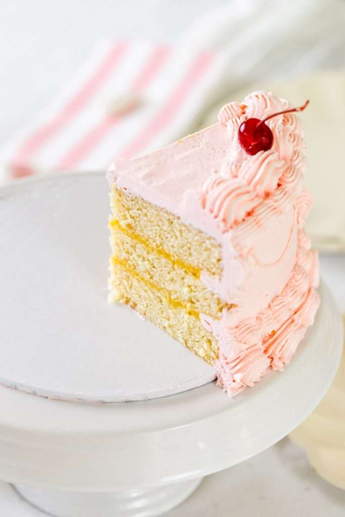 Homemade lemon lambeth cake with lemon curd and pink piped frosting.