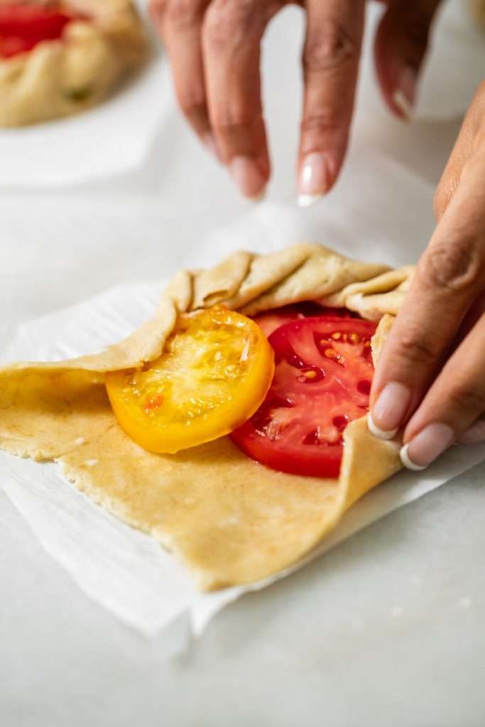 Mini tomato galettes, the perfect party appetizer or brunch treat! Flaky pastry, creamy goat cheese and fresh garden tomatoes, and baked until golden brown.