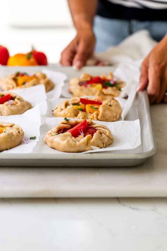 Mini tomato galettes, the perfect party appetizer or brunch treat! Flaky pastry, creamy goat cheese and fresh garden tomatoes, and baked until golden brown.