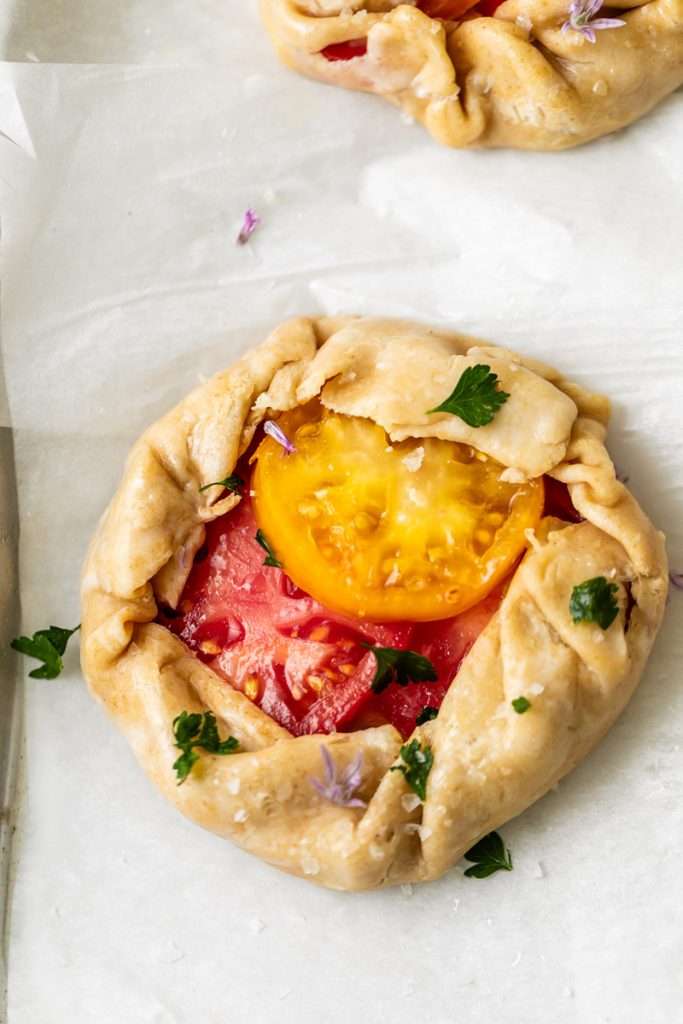 Mini tomato galettes, the perfect party appetizer or brunch treat! Flaky pastry, creamy goat cheese and fresh garden tomatoes, and baked until golden brown.