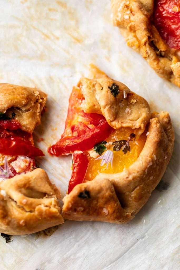 Mini tomato galettes, the perfect party appetizer or brunch treat! Flaky pastry, creamy goat cheese and fresh garden tomatoes, and baked until golden brown.