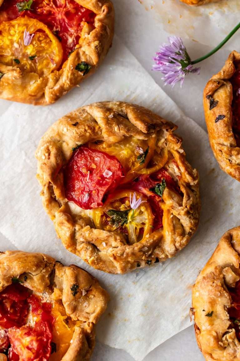Mini tomato galettes, the perfect party appetizer or brunch treat! Flaky pastry, creamy goat cheese and fresh garden tomatoes, and baked until golden brown.