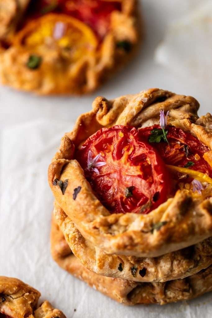 Mini tomato galettes, the perfect party appetizer or brunch treat! Flaky pastry, creamy goat cheese and fresh garden tomatoes, and baked until golden brown.