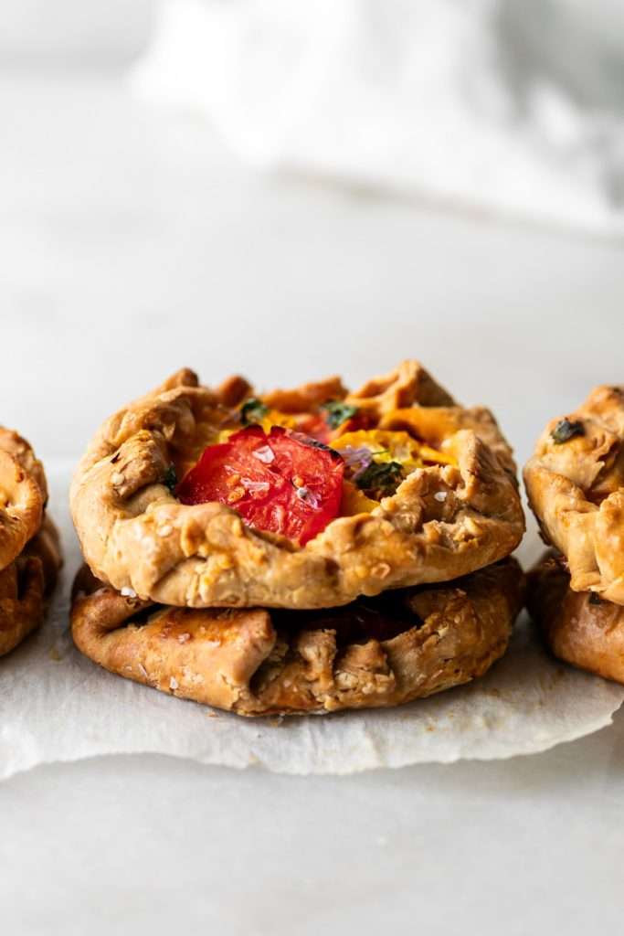 Mini tomato galettes, the perfect party appetizer or brunch treat! Flaky pastry, creamy goat cheese and fresh garden tomatoes, and baked until golden brown.