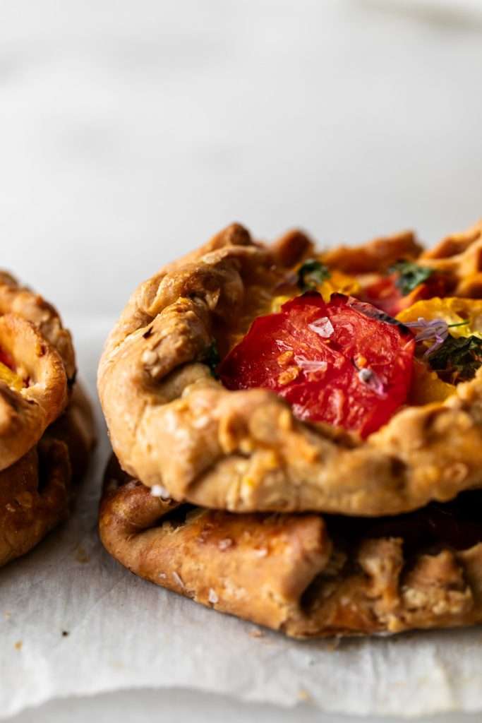 Mini tomato galettes, the perfect party appetizer or brunch treat! Flaky pastry, creamy goat cheese and fresh garden tomatoes, and baked until golden brown.