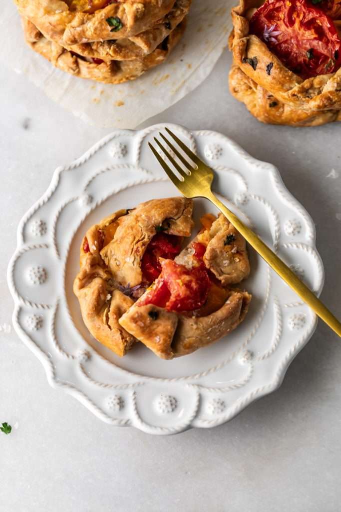 Mini tomato galettes, the perfect party appetizer or brunch treat! Flaky pastry, creamy goat cheese and fresh garden tomatoes, and baked until golden brown.