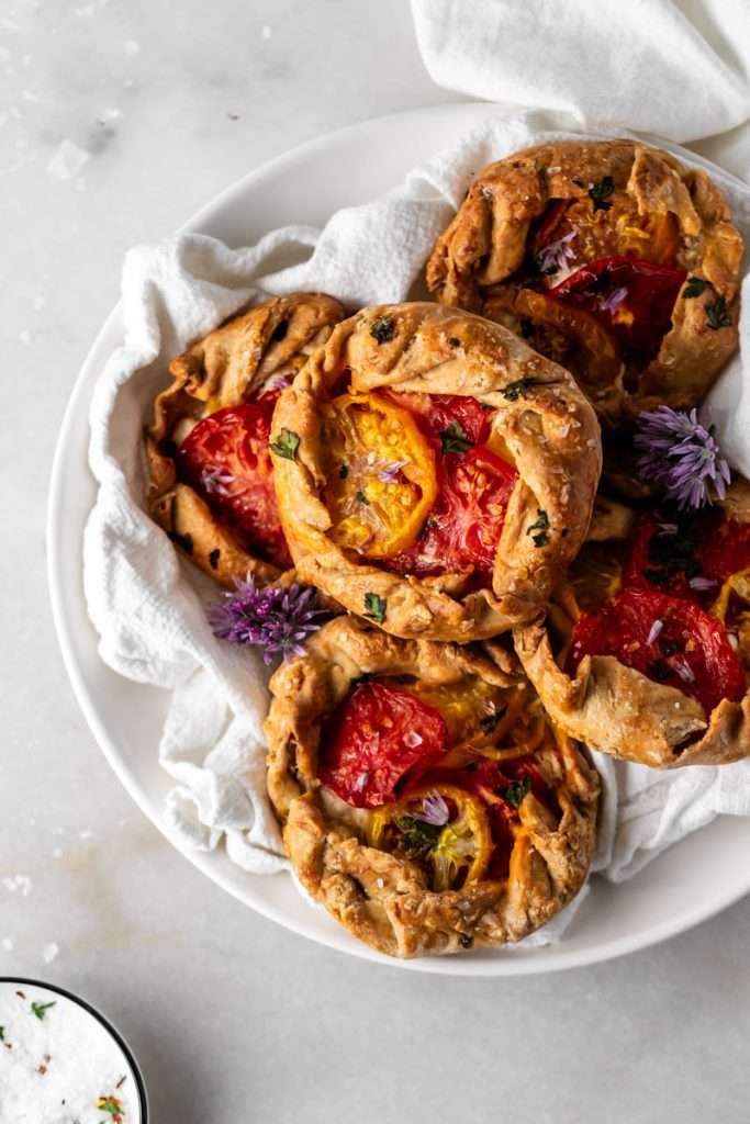 Mini tomato galettes, the perfect party appetizer or brunch treat! Flaky pastry, creamy goat cheese and fresh garden tomatoes, and baked until golden brown.
