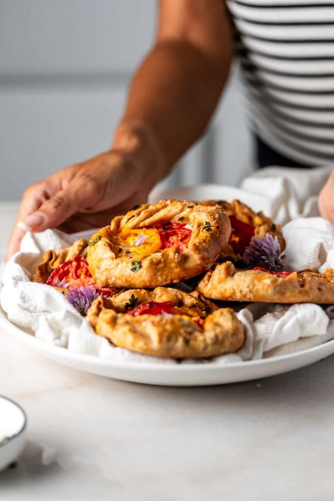 Mini tomato galettes, the perfect party appetizer or brunch treat! Flaky pastry, creamy goat cheese and fresh garden tomatoes, and baked until golden brown.