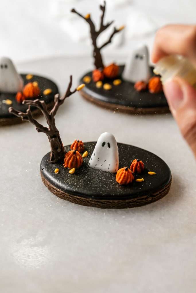 These 3D chocolate sugar cookies are decorated with rich chocolate royal icing and festive Halloween details. Featuring spooky icing transfers, they are not only delicious but perfect for dessert tables. cookie decorating inspiration and halloween themed parties.