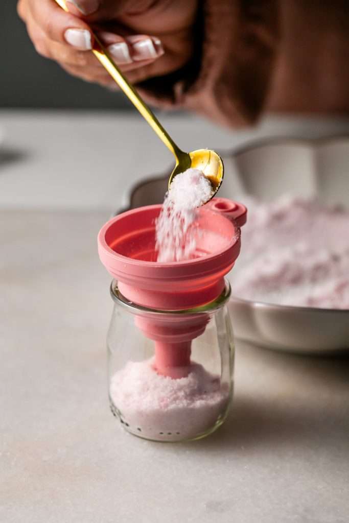 Sparkling sugared cranberries coated in sugar in a glass dish, perfect as a festive holiday garnish.