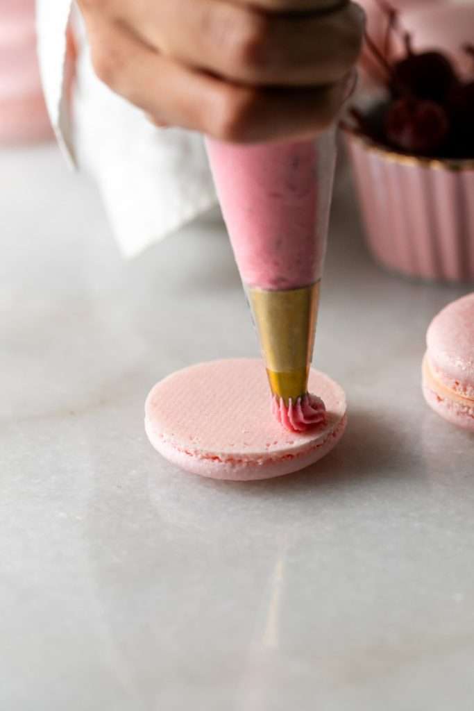 Shirley Temple macarons filled with cherry grenadine gel, and lime buttercream, toped with a glossy cherry.