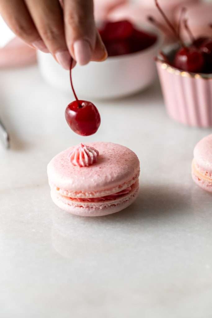 Shirley Temple macarons filled with cherry grenadine gel, and lime buttercream, toped with a glossy cherry.
