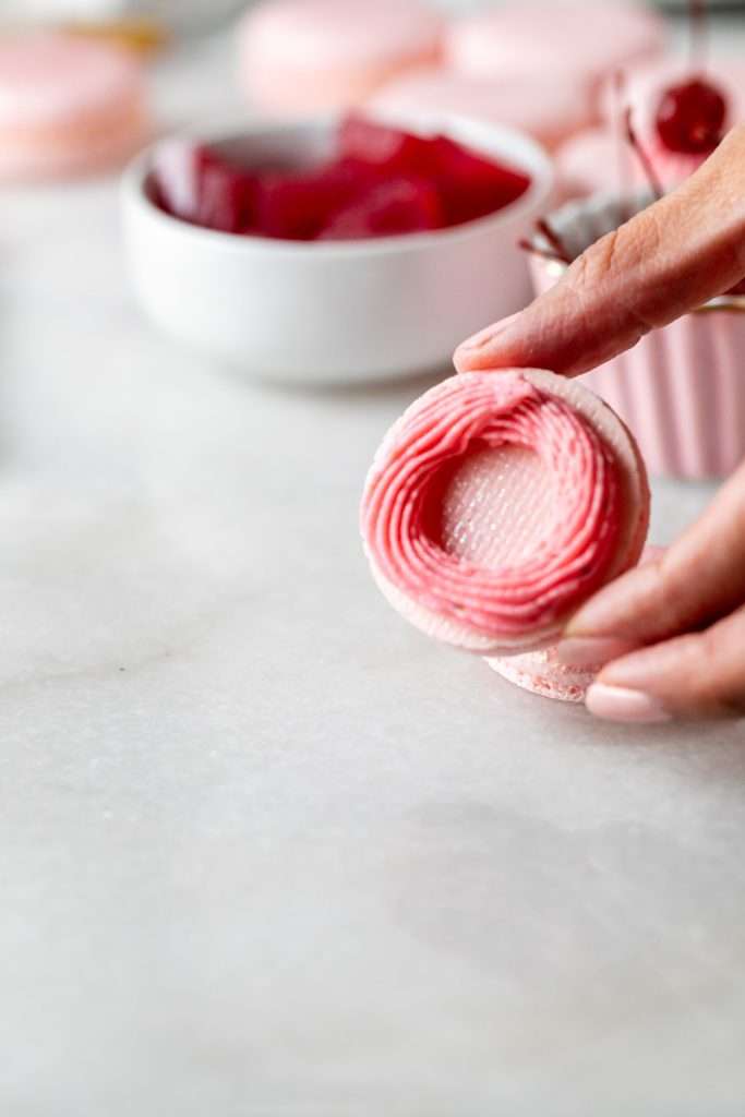 Shirley Temple macarons filled with cherry grenadine gel, and lime buttercream, toped with a glossy cherry.