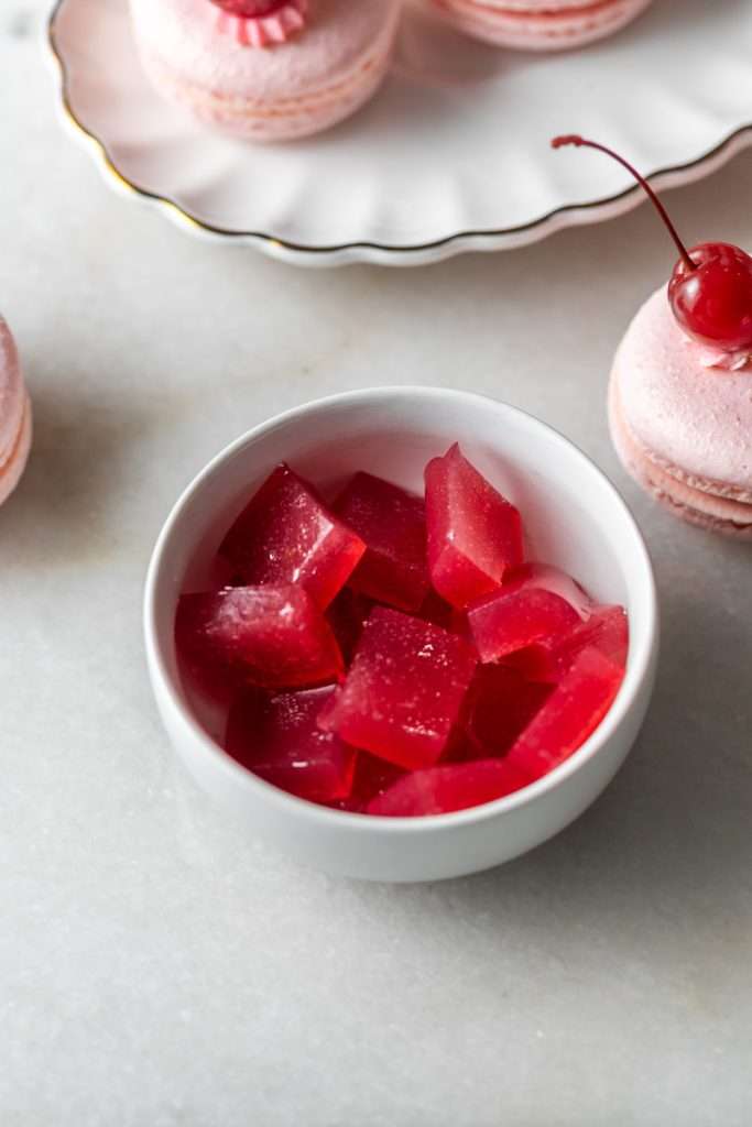 Shirley Temple macarons filled with cherry grenadine gel, and lime buttercream, toped with a glossy cherry.