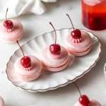 Shirley Temple macarons filled with cherry grenadine gel, and lime buttercream, toped with a glossy cherry.