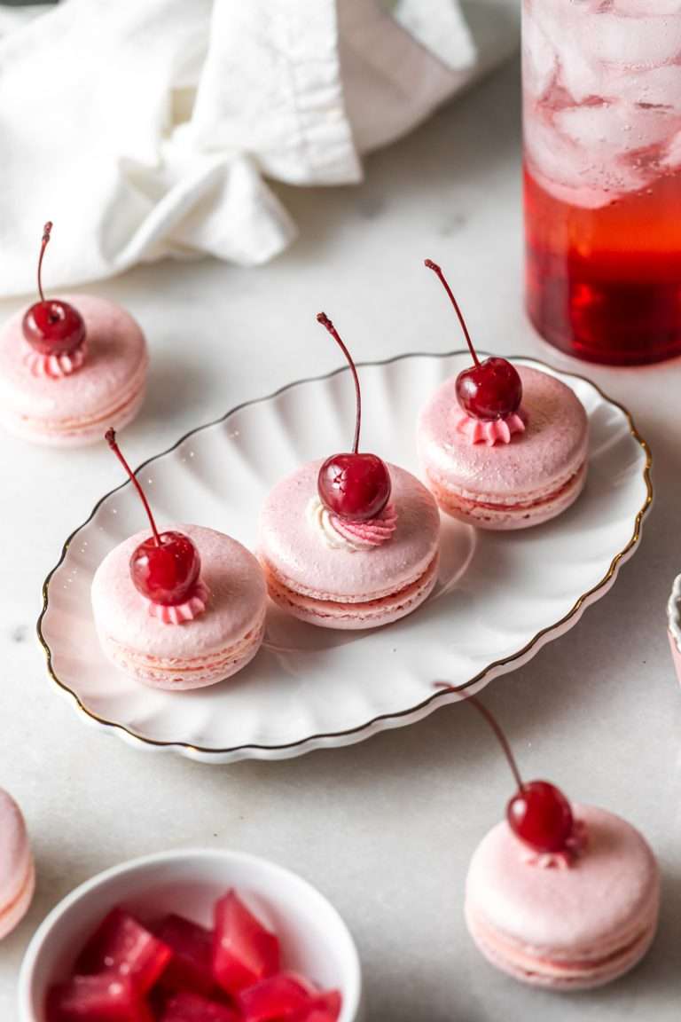 Shirley Temple macarons filled with cherry grenadine gel, and lime buttercream, toped with a glossy cherry.