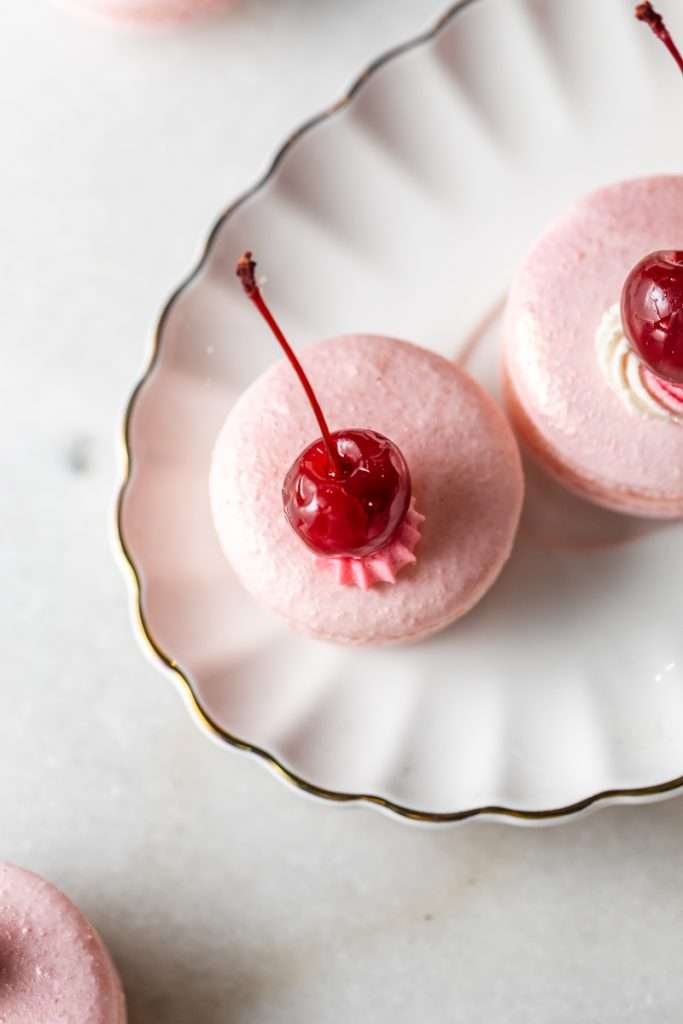 Shirley Temple macarons filled with cherry grenadine gel, and lime buttercream, toped with a glossy cherry.