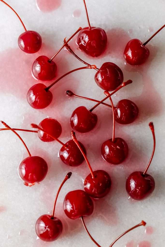 Shirley Temple macarons filled with cherry grenadine gel, and lime buttercream, toped with a glossy cherry.