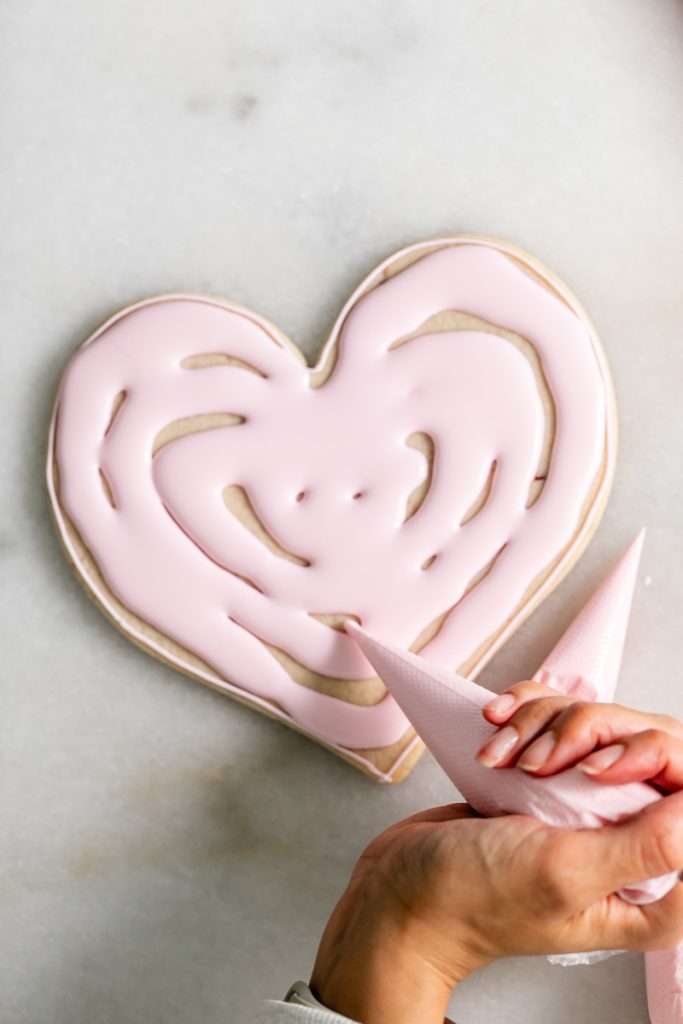 These Cherry Chip sugar cookies are inspired by the classic cherry chip cake! They are soft, buttery and studded with bites of maraschino cherries throughout. Topped with royal icing for a sweet and delicious finish. Perfect for Valentine's Day, birthdays or any festive celebration.