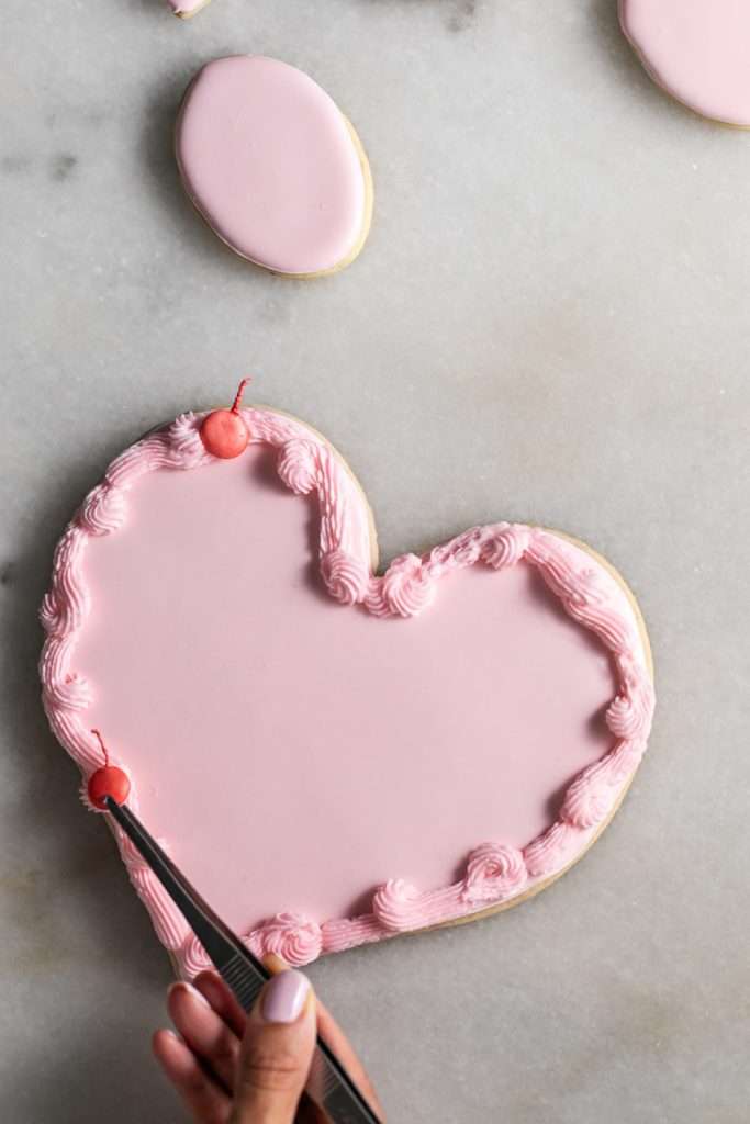 These Cherry Chip sugar cookies are inspired by the classic cherry chip cake! They are soft, buttery and studded with bites of maraschino cherries throughout. Topped with royal icing for a sweet and delicious finish. Perfect for Valentine's Day, birthdays or any festive celebration.