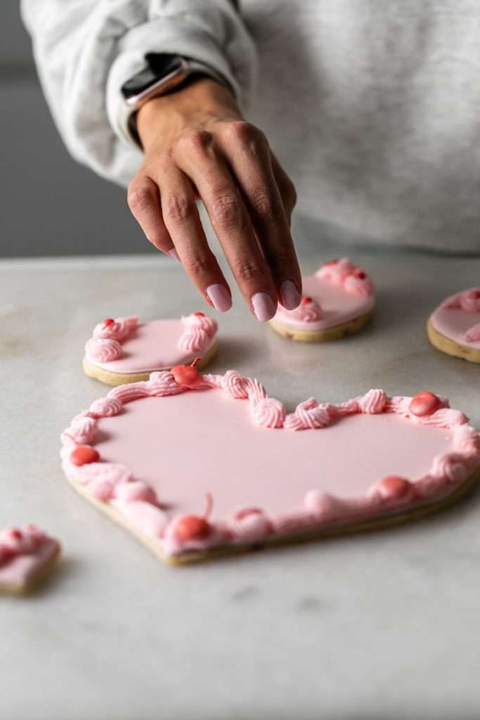 These Cherry Chip sugar cookies are inspired by the classic cherry chip cake! They are soft, buttery and studded with bites of maraschino cherries throughout. Topped with royal icing for a sweet and delicious finish. Perfect for Valentine's Day, birthdays or any festive celebration.