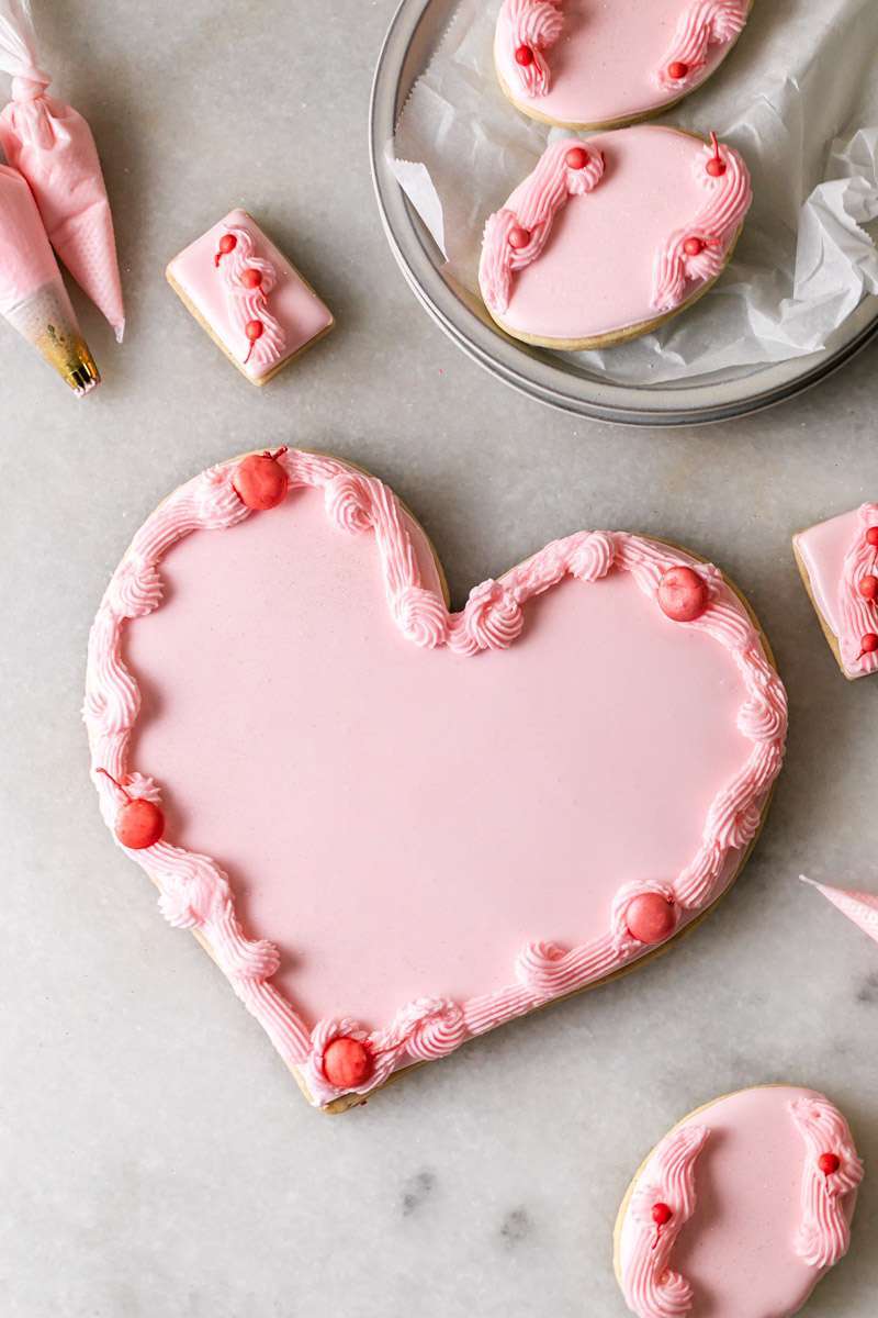 These Cherry Chip sugar cookies are inspired by the classic cherry chip cake! They are soft, buttery and studded with bites of maraschino cherries throughout. Topped with royal icing for a sweet and delicious finish. Perfect for Valentine's Day, birthdays or any festive celebration.