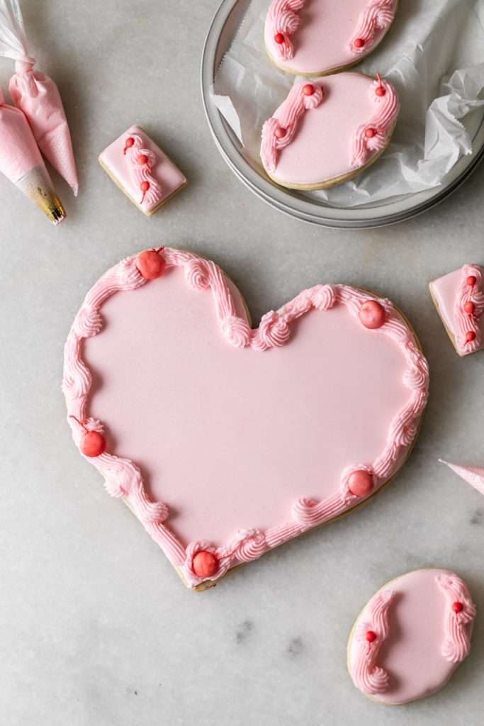 These Cherry Chip sugar cookies are inspired by the classic cherry chip cake! They are soft, buttery and studded with bites of maraschino cherries throughout. Topped with royal icing for a sweet and delicious finish. Perfect for Valentine's Day, birthdays or any festive celebration.