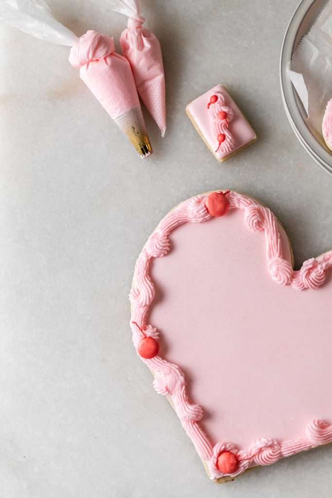 These Cherry Chip sugar cookies are inspired by the classic cherry chip cake! They are soft, buttery and studded with bites of maraschino cherries throughout. Topped with royal icing for a sweet and delicious finish. Perfect for Valentine's Day, birthdays or any festive celebration.