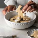 Shaped peanut butter sugar cookies dipped in chocolate and arranged in a serving bowl.