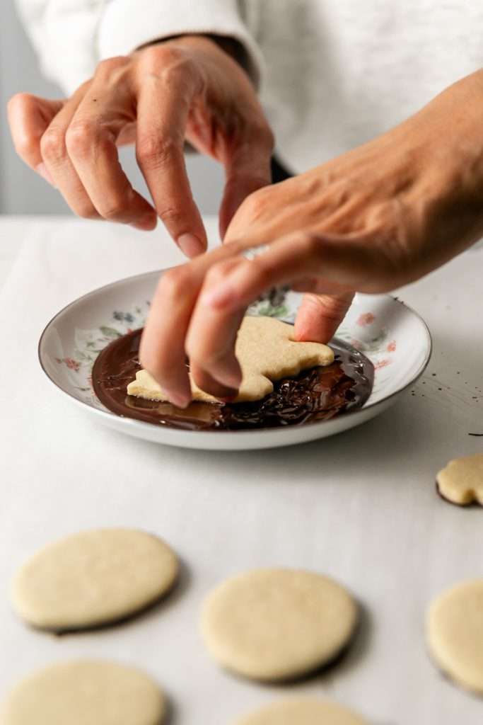 Shaped peanut butter sugar cookies dipped in chocolate and arranged in a serving bowl.