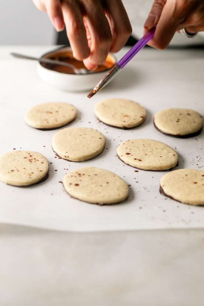 Shaped peanut butter sugar cookies dipped in chocolate and arranged in a serving bowl.