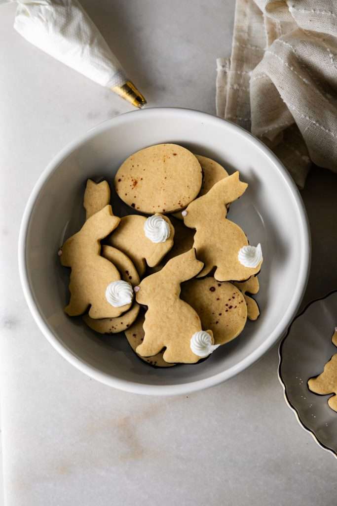 Shaped peanut butter sugar cookies dipped in chocolate and arranged in a serving bowl.