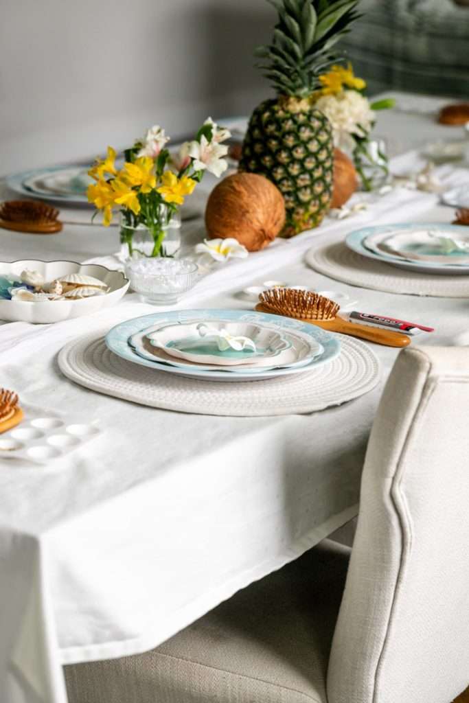 A modern tropical teen birthday party featuring a DIY dirty soda bar, colorful syrups, tropical desserts, and elevated tropical themed party decor in shades of blue and pink.