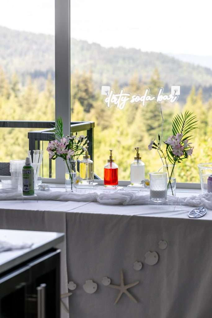 Tropical themed dirty soda bar with flavored syrups, creamer and garnishes.